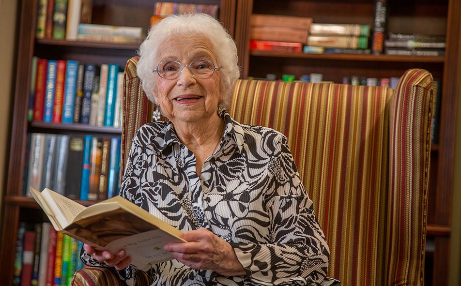 The library at The Lodge at Wake Forest with shelves of books and comfortable seating